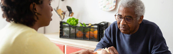 Man having a meal at home with a caregiver.